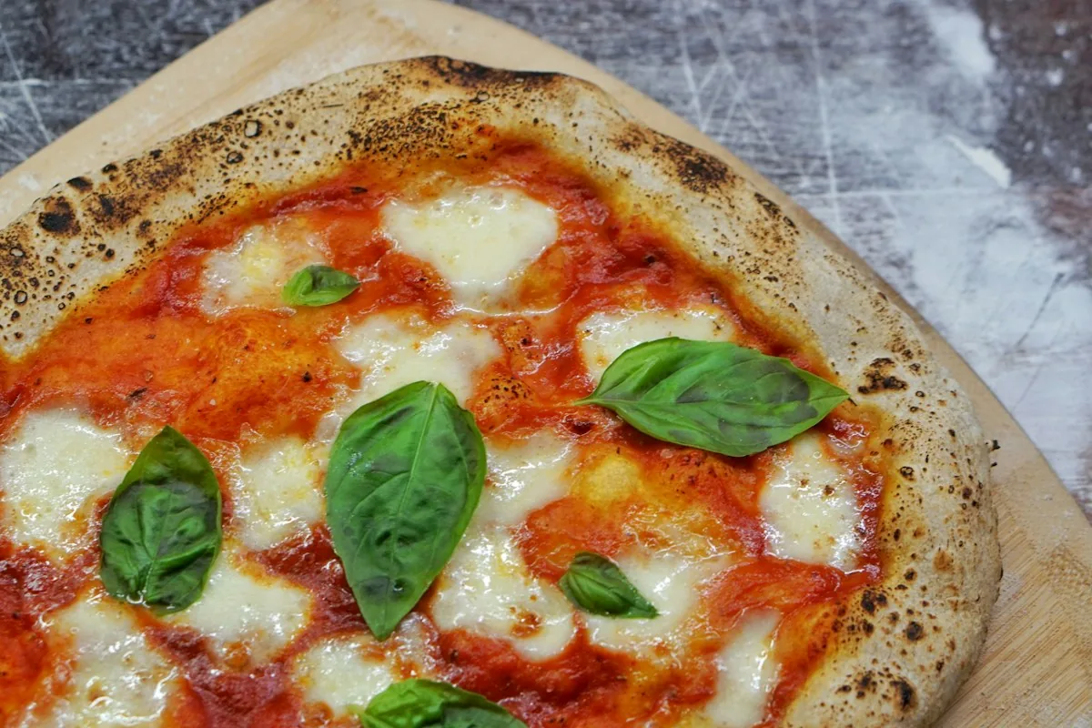 Pizza Margherita maison garnie de basilic